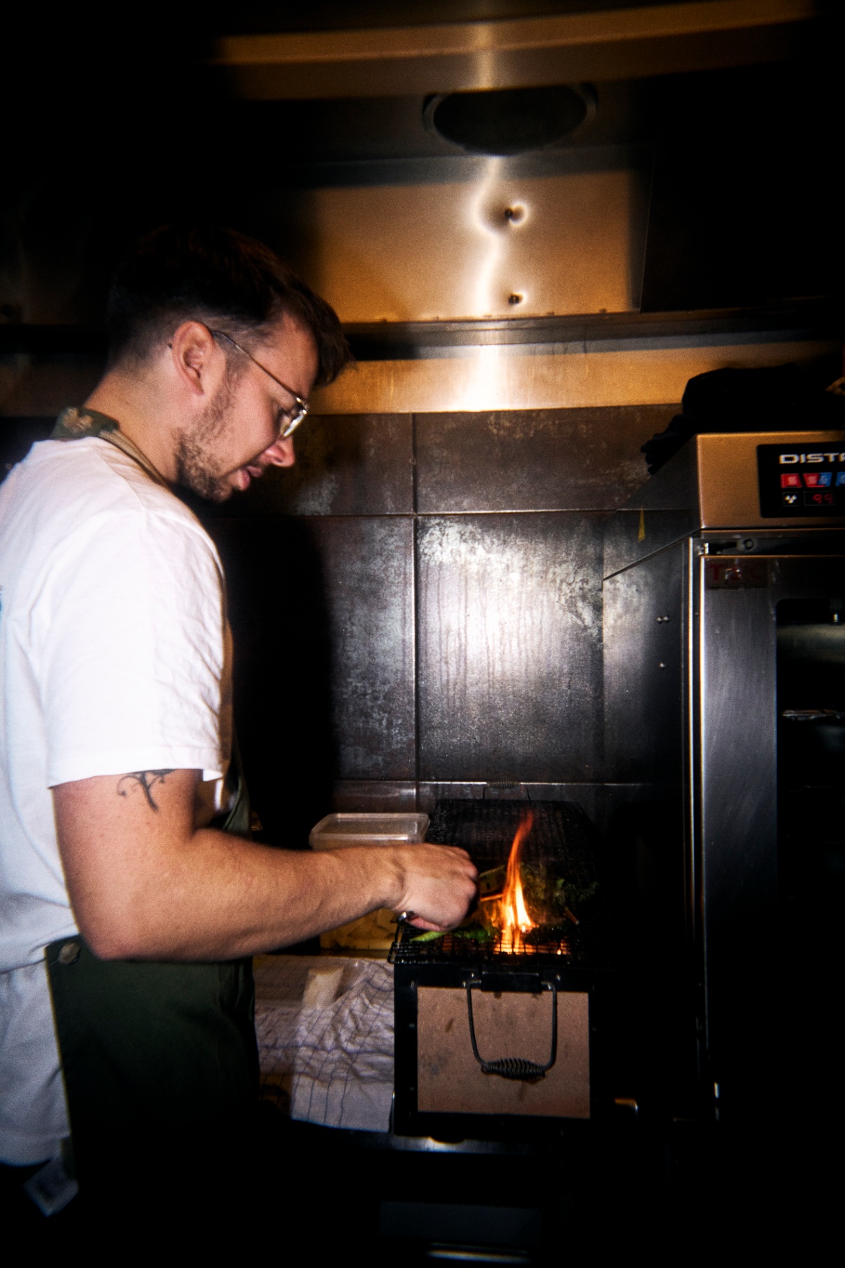 Casper griller over åben ild i køkkenet på Restaurant Grim