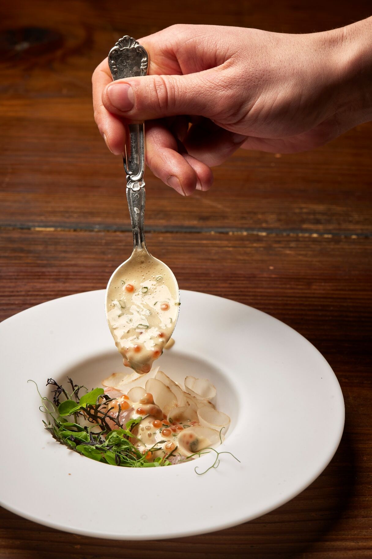 Grillet ret med urter på mørk tallerken, serveret hos Restaurant Grim